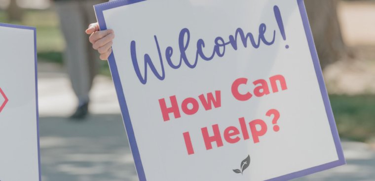 sign saying "How can I help?"